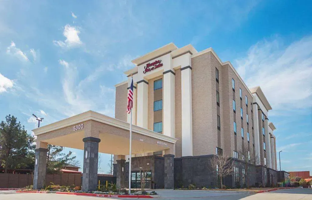 A large hotel with a flag flying in front of it.