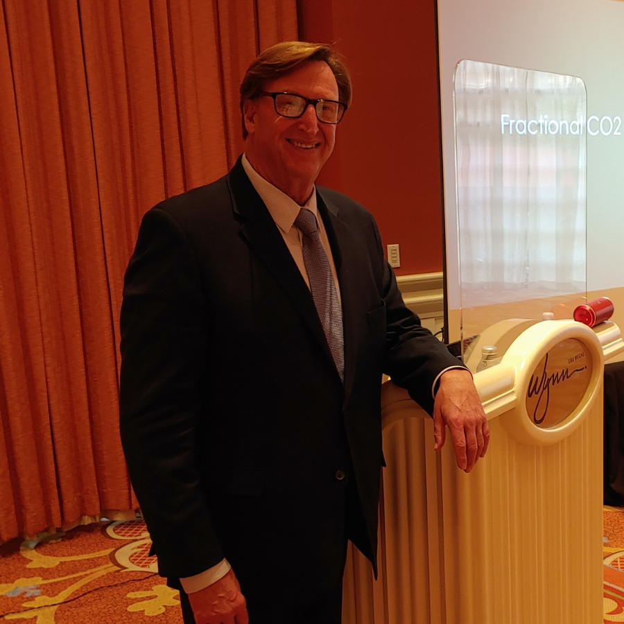 A man in a suit and tie is standing in front of a podium.