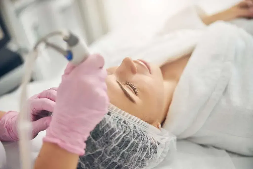 A woman is getting a facial treatment in a beauty salon.