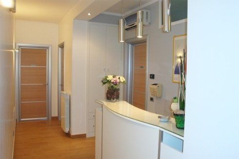 Ricezione della consultazione con moderni mobili di colore bianco combinato con l'uso del legno