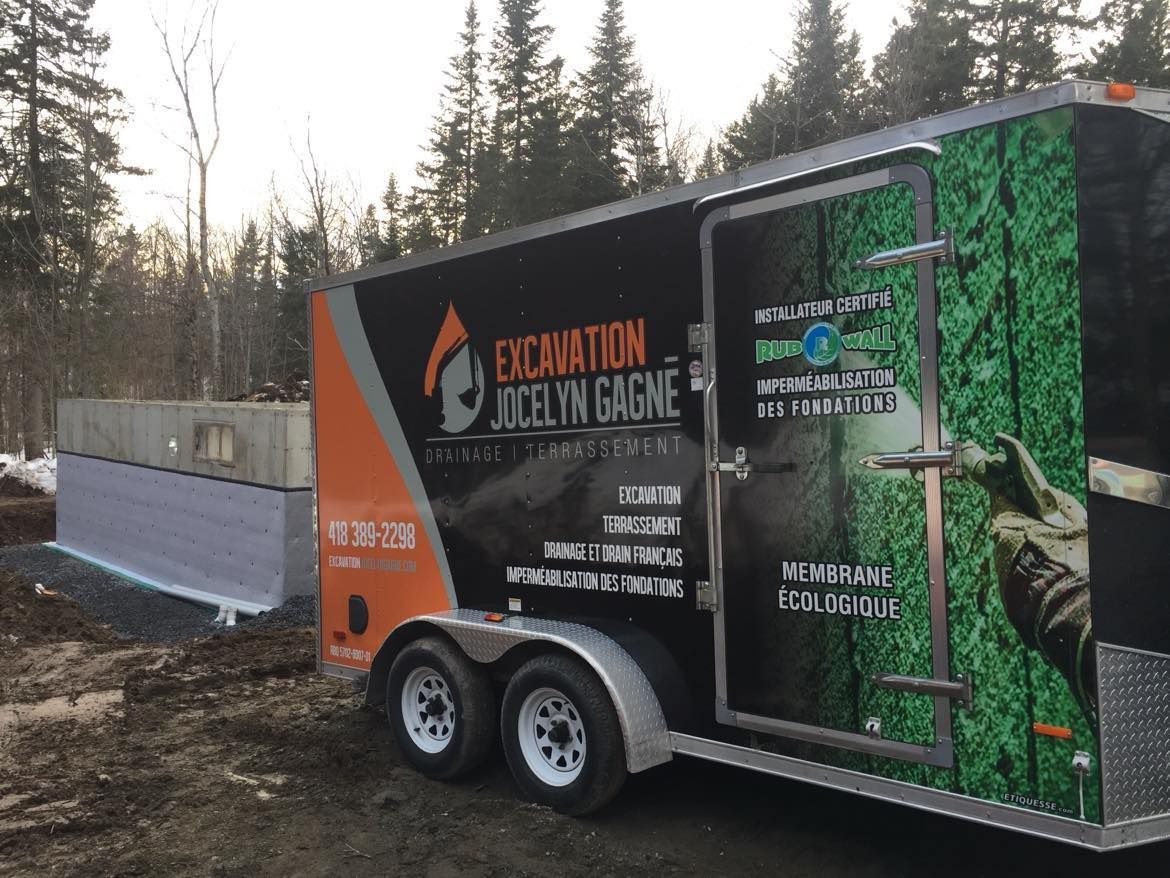 Une remorque avec le mot excavation dessus est garée dans la terre.