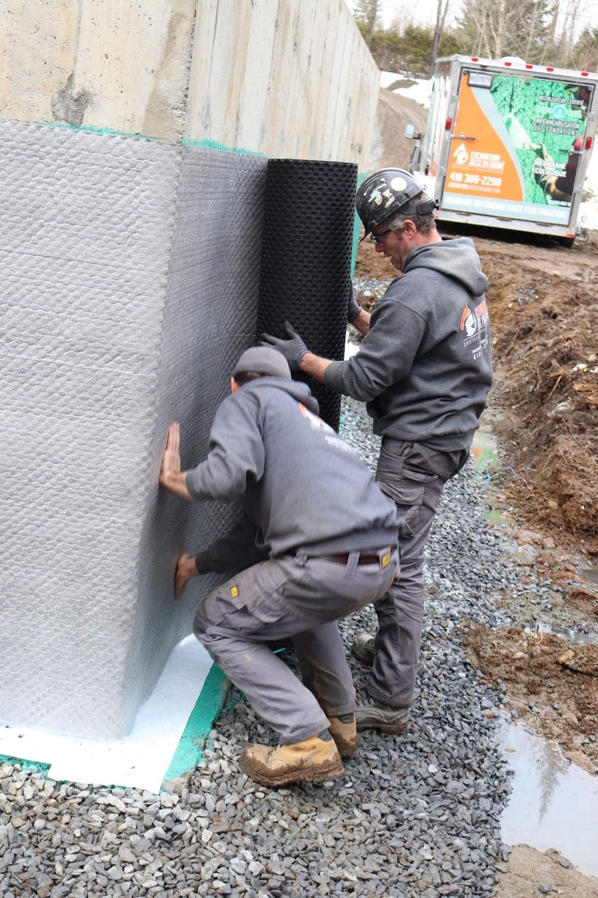 Deux ouvriers recouvrant un mur