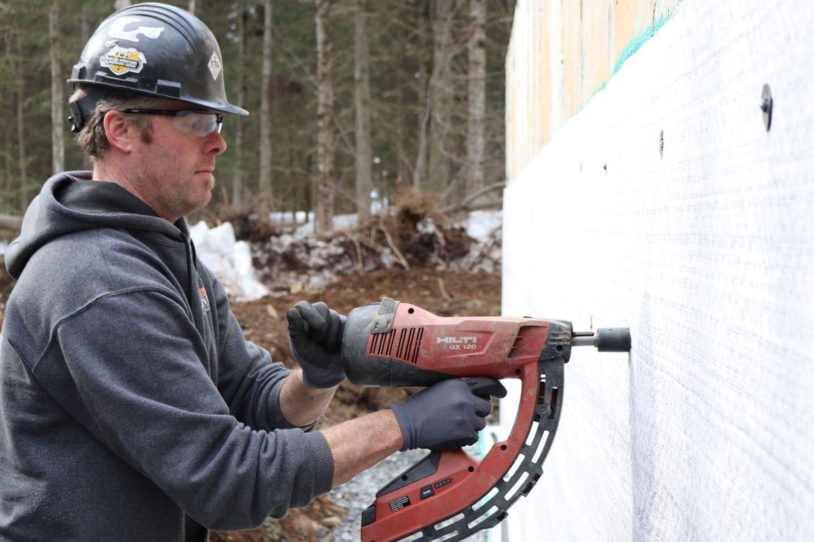 un homme travaillent sur un mur de béton.