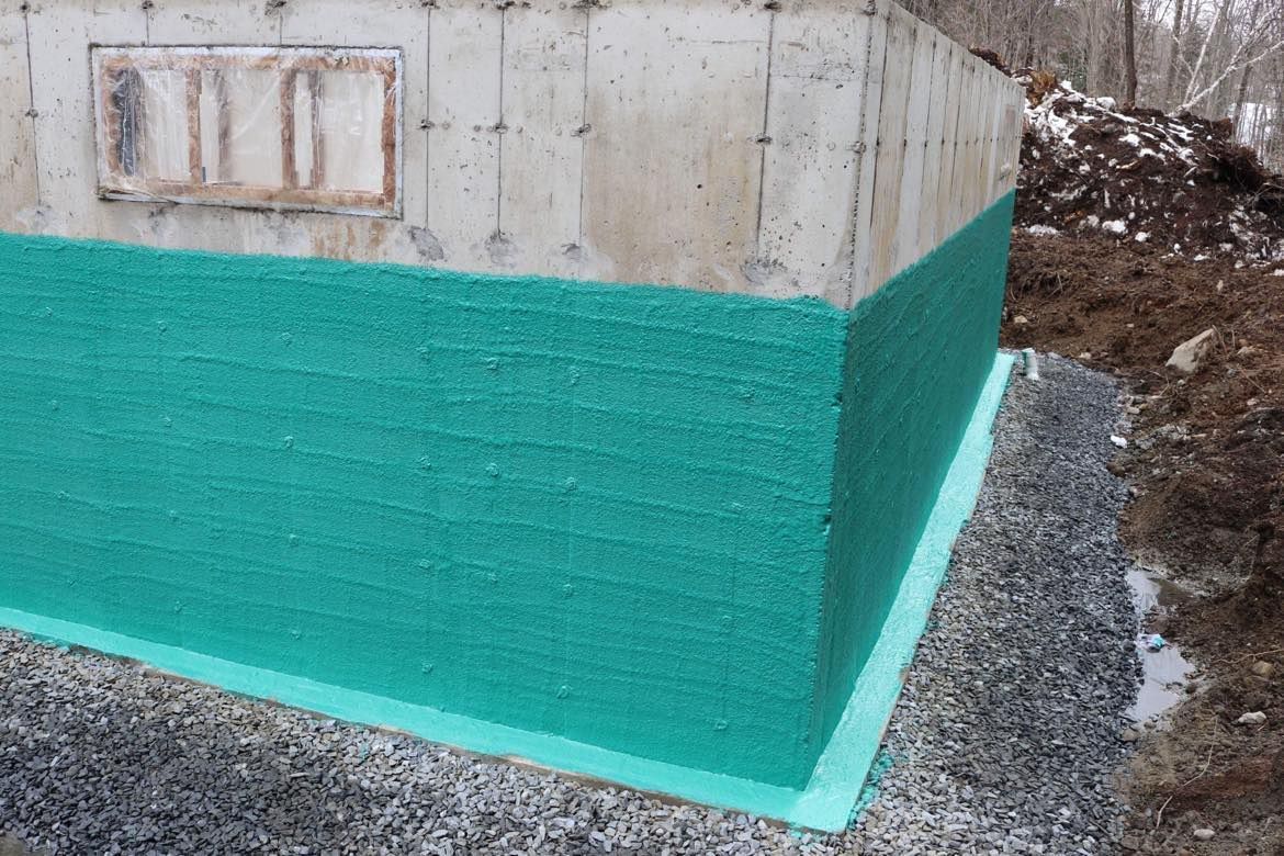 Le coin d'un mur en béton est peint en vert.