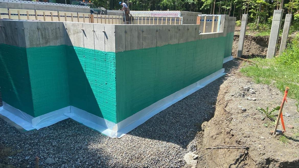 Un mur de béton avec de la peinture verte et blanche est en cours de construction.