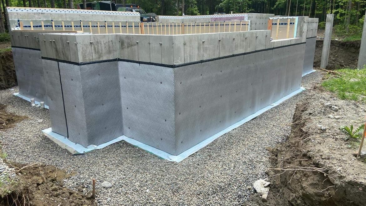 Un grand mur de béton repose sur un tas de gravier.