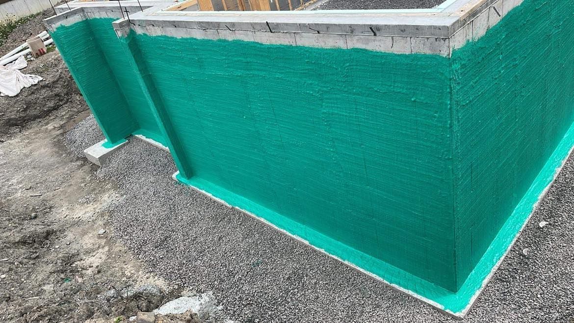 Étanchéité écologique appliquée à une structure en béton extérieure, avec un revêtement de sol en gravier.