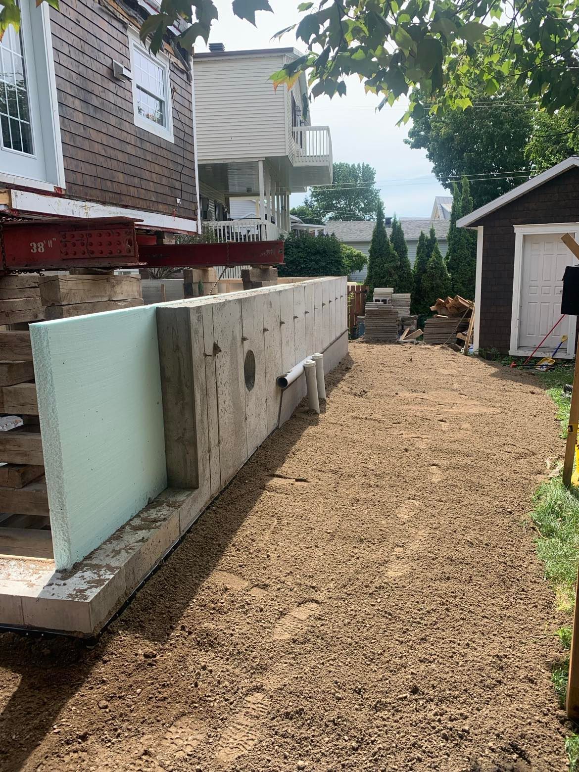 Un grand mur de béton est en construction devant une maison.