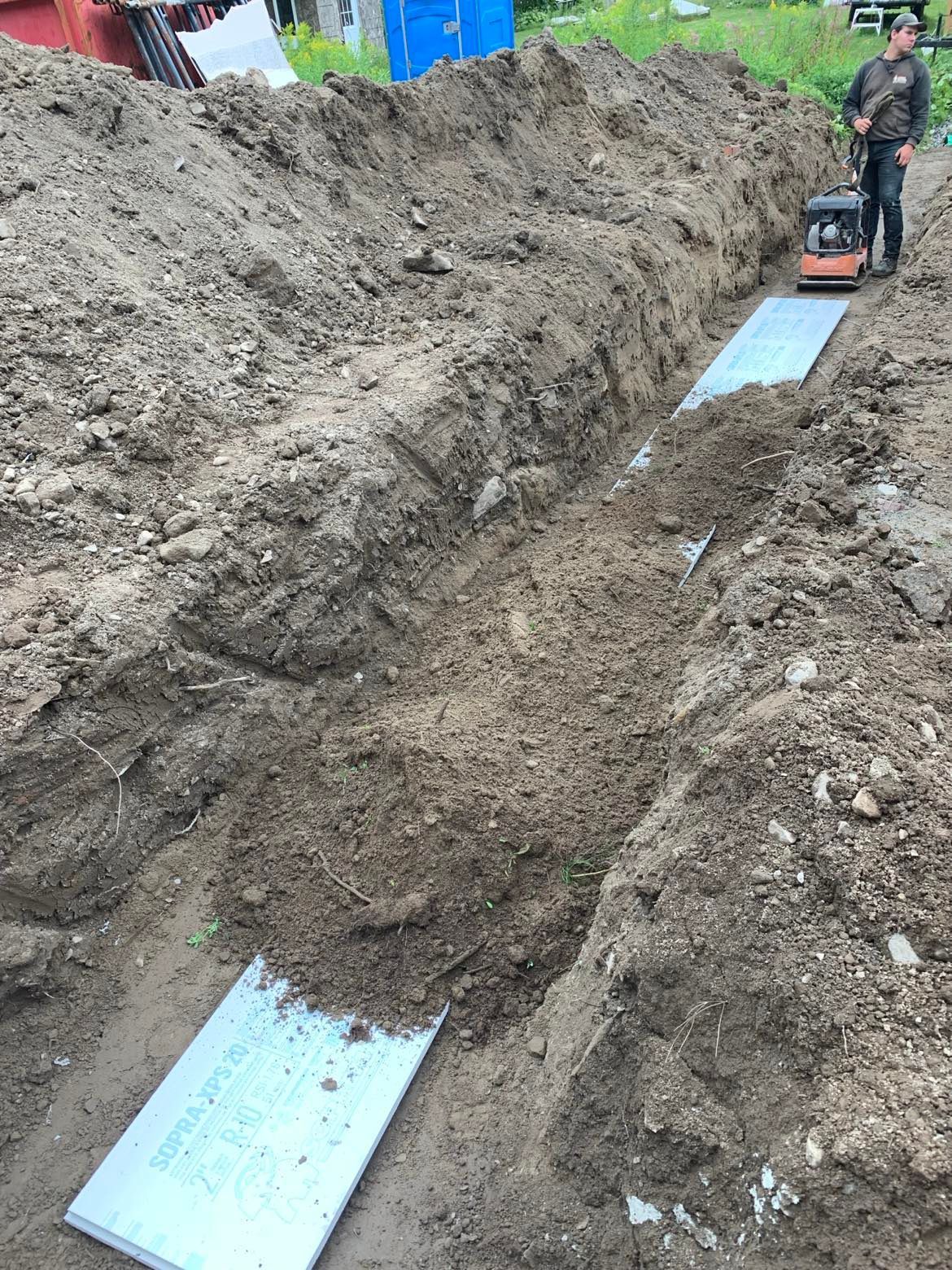 Un homme creuse une tranchée dans la terre.
