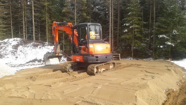 Une petite pelle orange est posée sur un tas de terre.