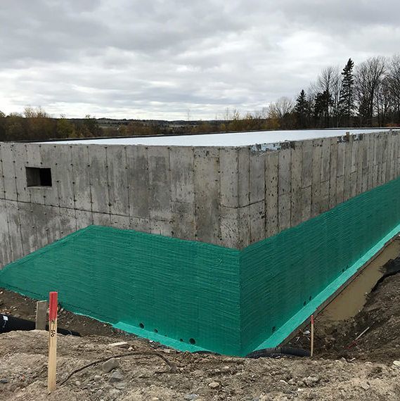 Un grand mur de béton avec une bordure verte est en cours de construction.