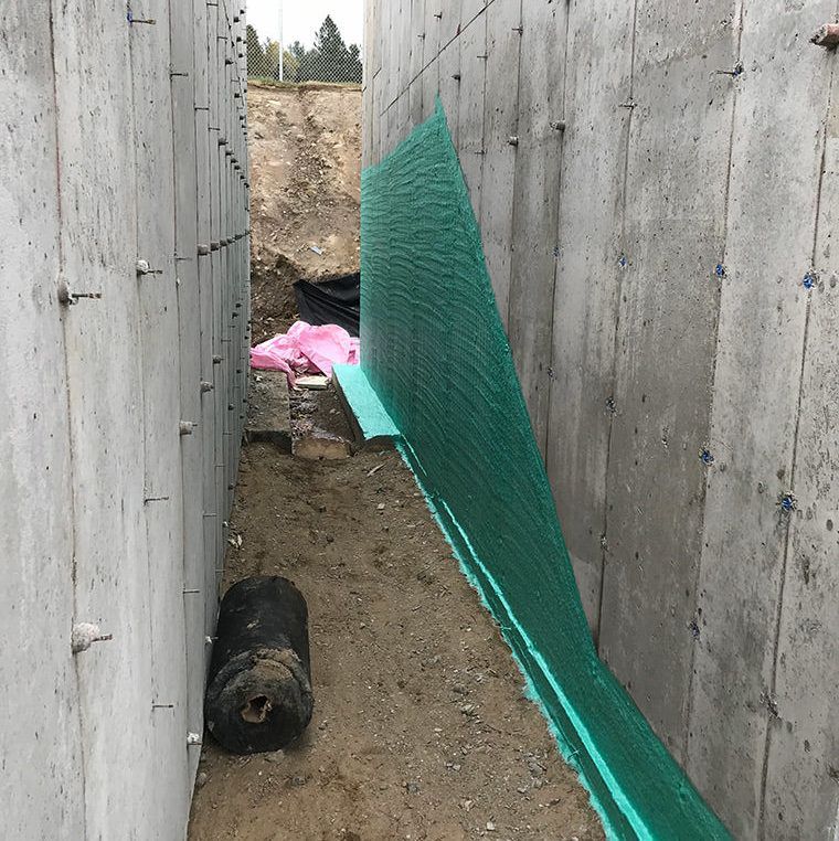 Un mur de béton avec un rouleau de mousse verte dessus.