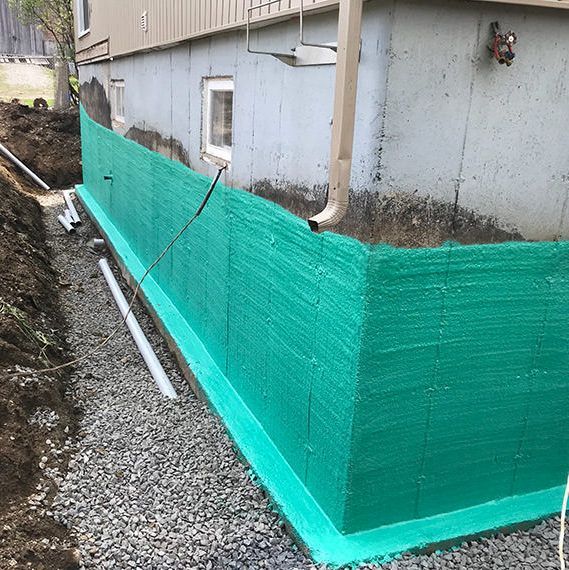 Une barrière verte est en cours d'installation sur le côté d'une maison.