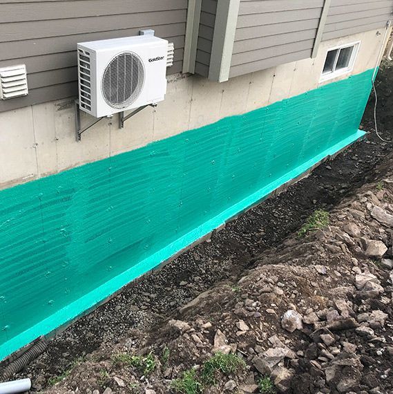 Un climatiseur blanc est monté sur le côté d’une maison.
