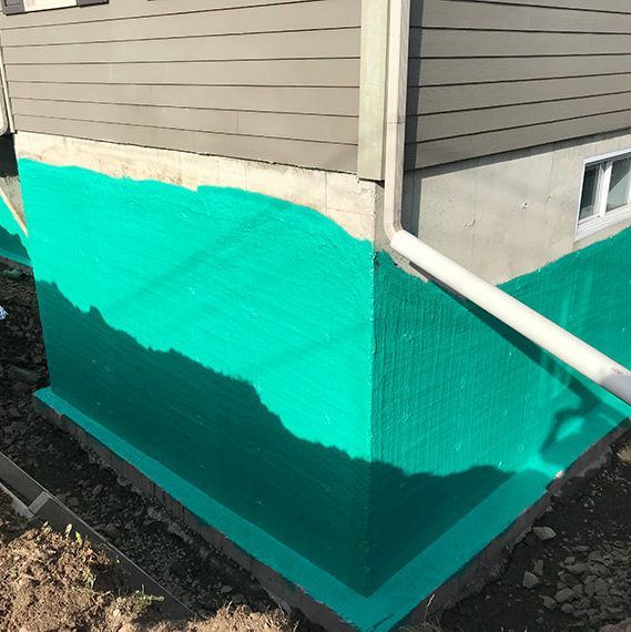 Le coin d’une maison est peint en vert.