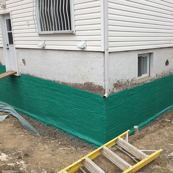 Une échelle se trouve sur le côté d’une maison.