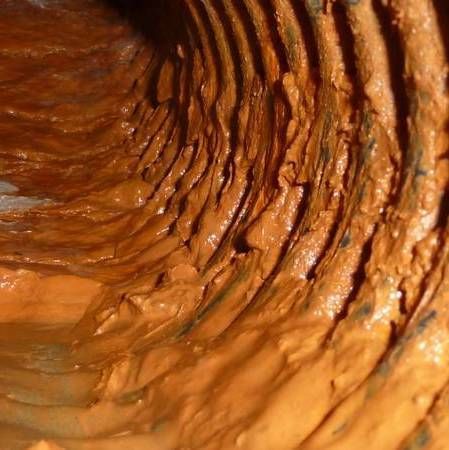 Un gros plan de l'intérieur d'une pipe recouverte d';argile brune