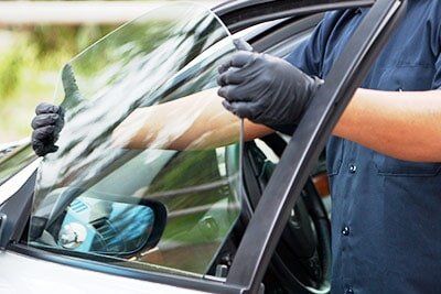 Auto Glass Replacements — Mechanic Removing the Door Glass in Detroit, MI