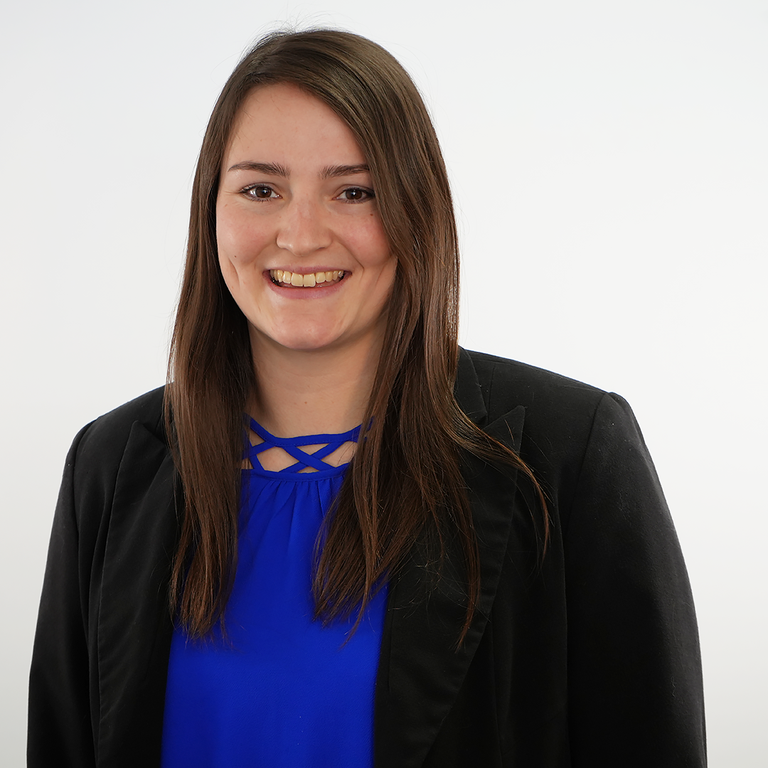 A man wearing glasses and a suit is smiling for the camera.