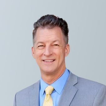 A man in a suit and tie is smiling for the camera.