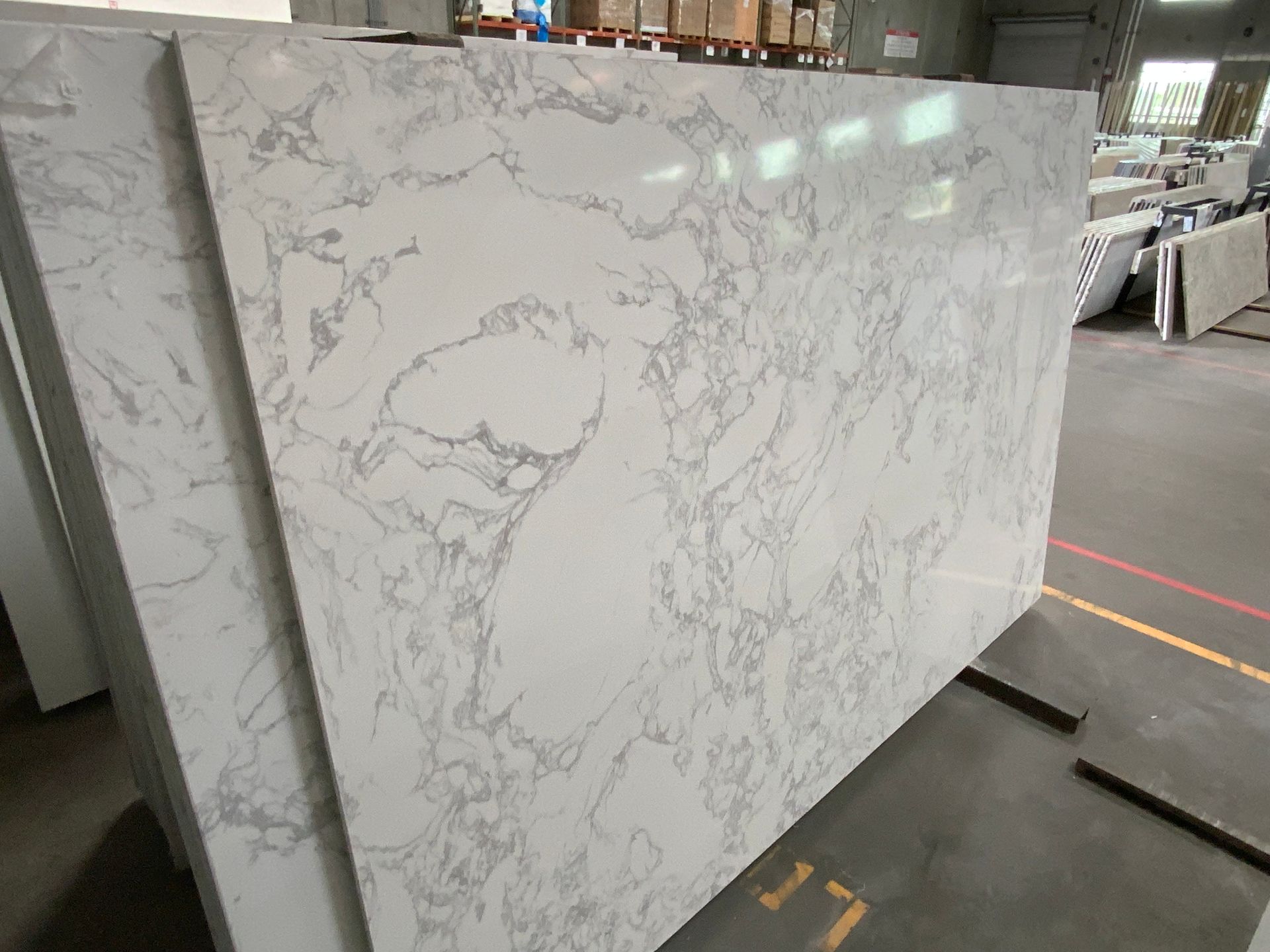 A stack of white marble slabs sitting on top of each other in a warehouse.