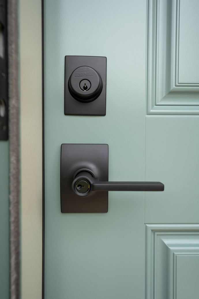 A close up of a door with a black handle and lock.