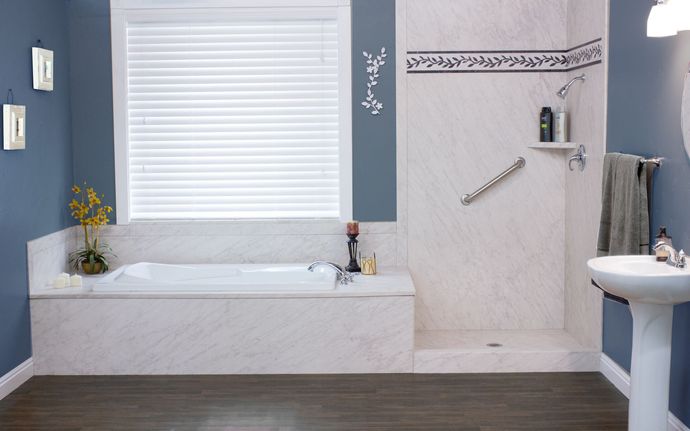 A bathroom with a tub , sink , and shower.