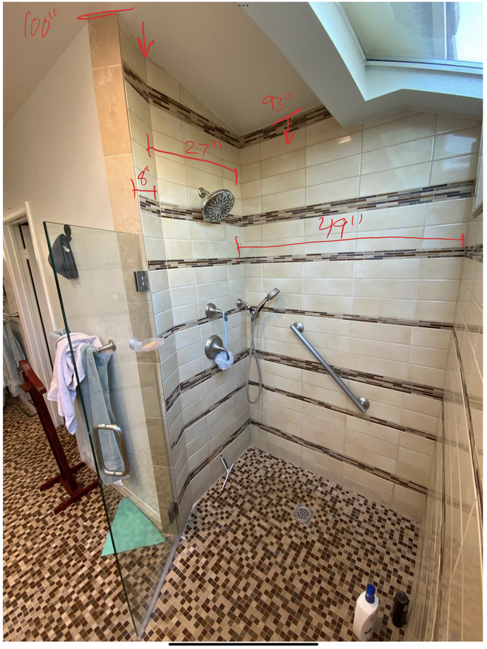 A bathroom with a walk in shower and a tiled floor.