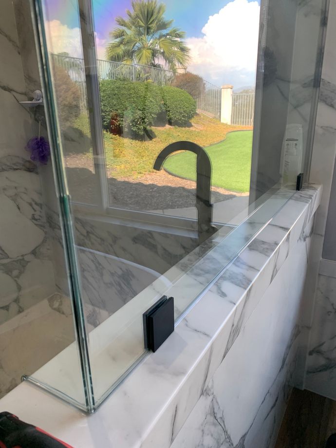 A bathroom with a glass shower door and a faucet.