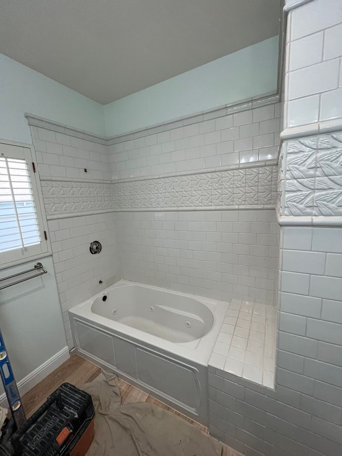 A bathroom with a bathtub and a window.