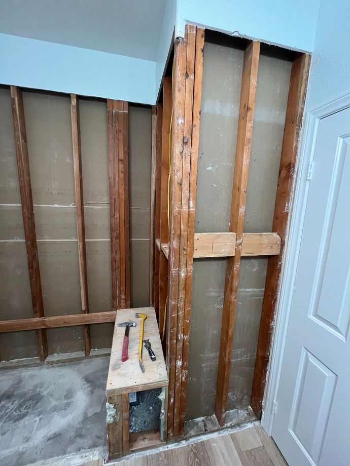 A room with a wooden wall and a wooden bench with tools on it.