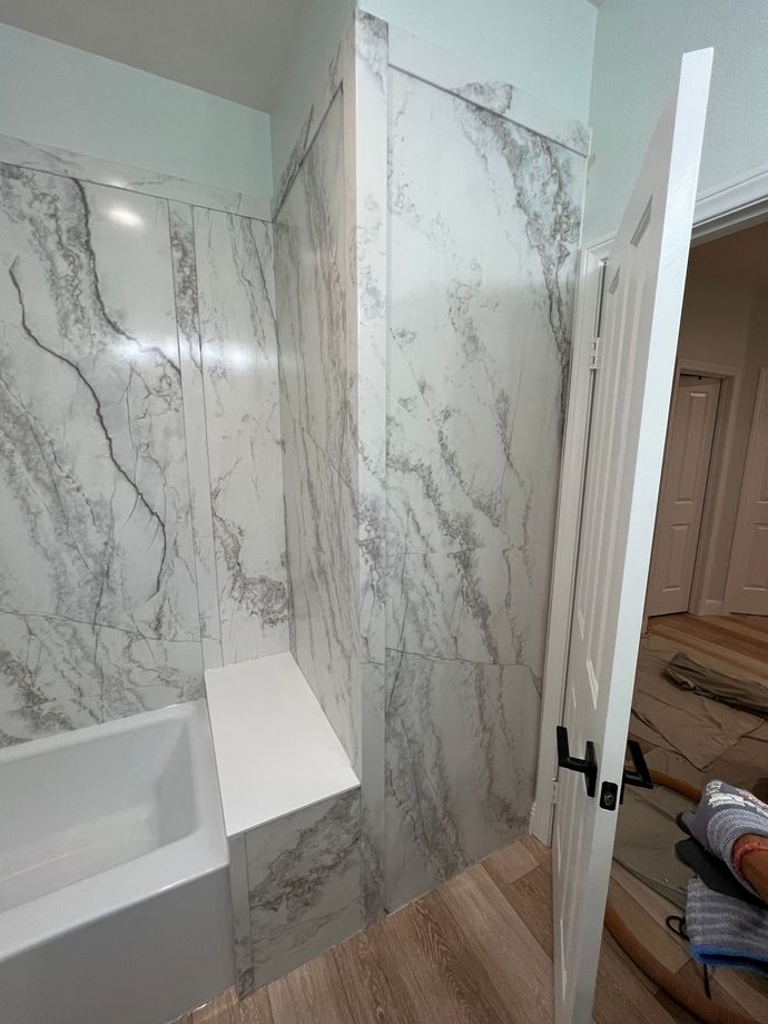 A bathroom with marble walls and a bathtub