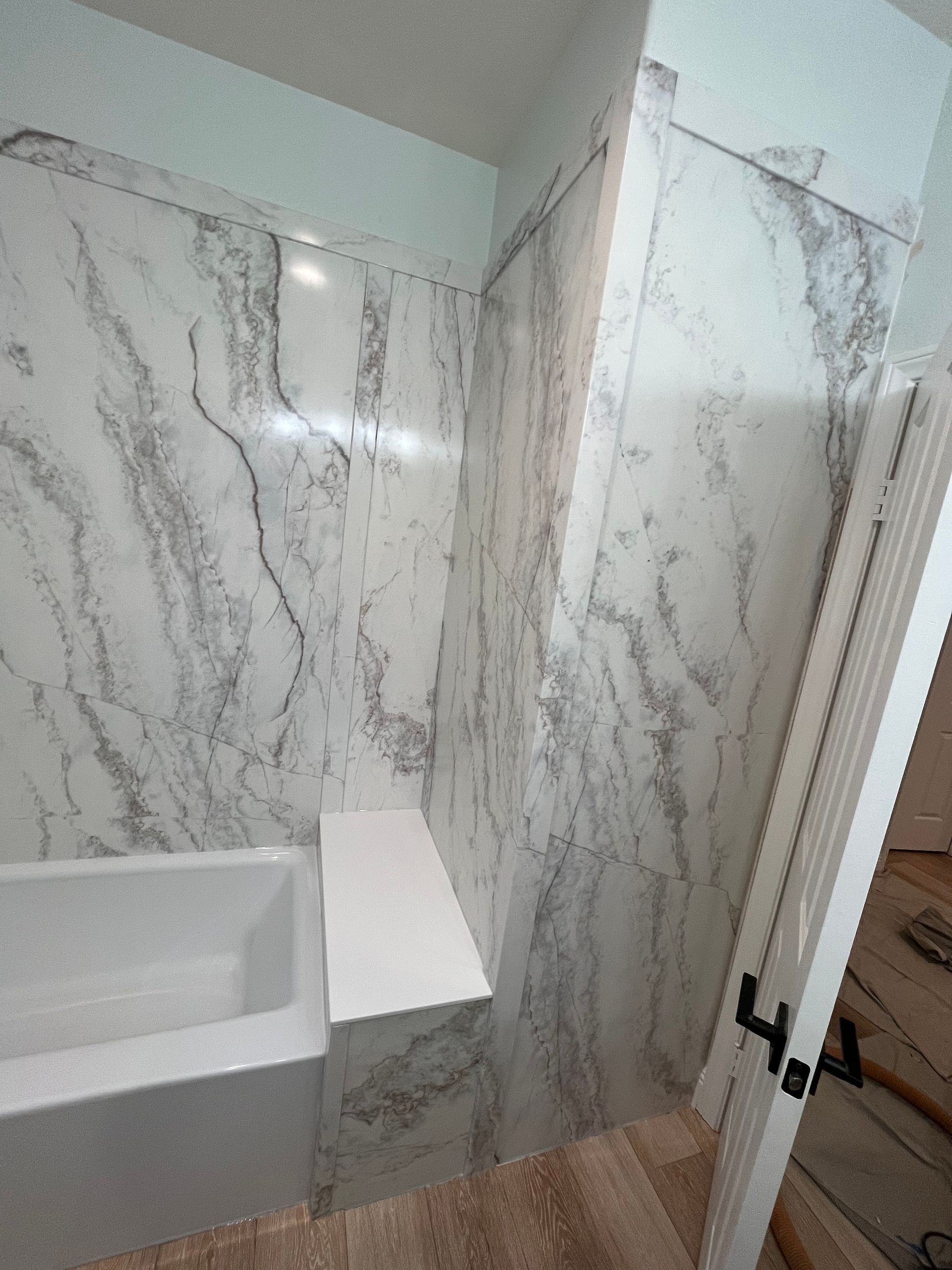 A bathroom with marble walls and a bathtub.