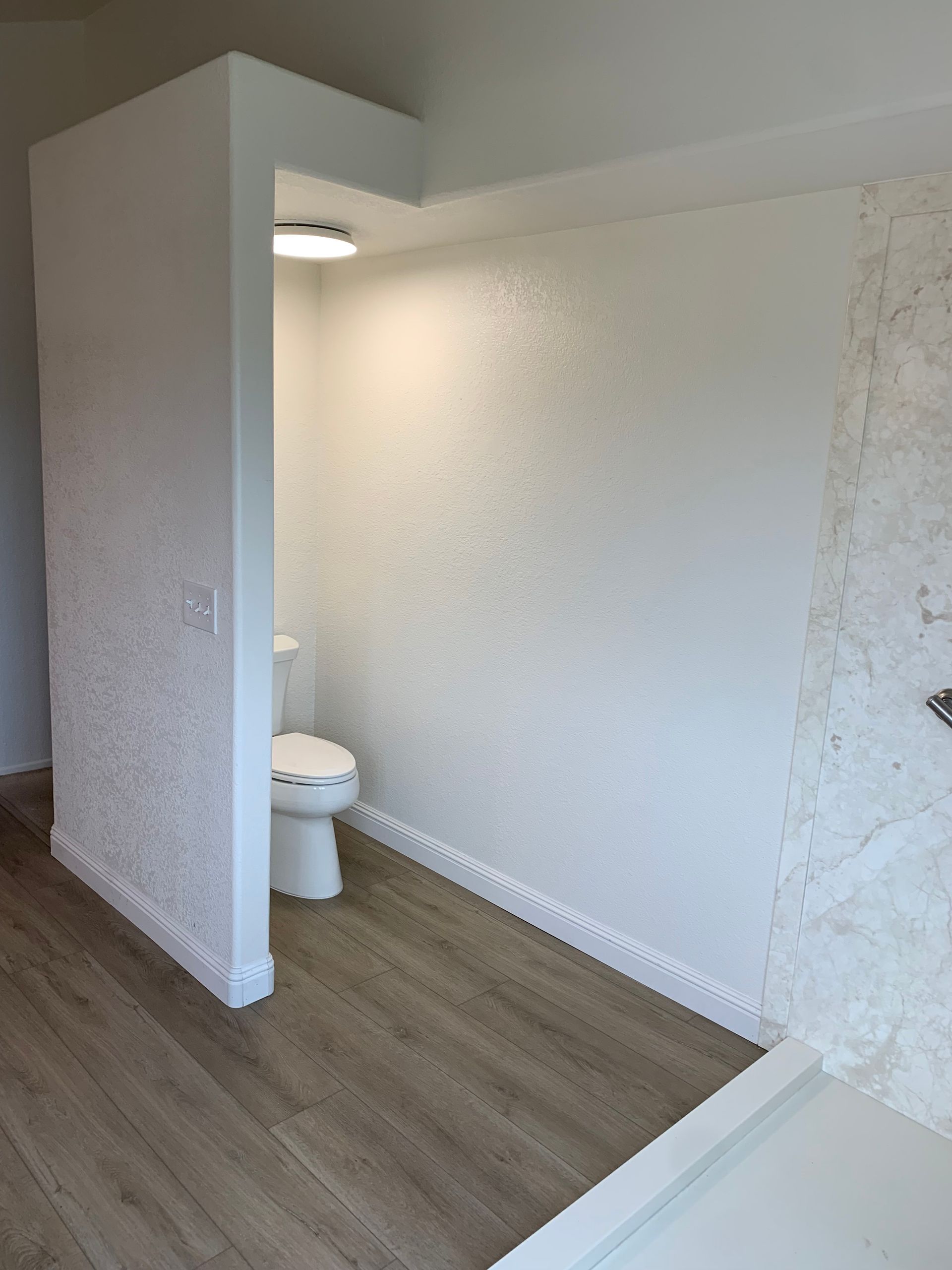 A bathroom with a toilet and a bathtub in it