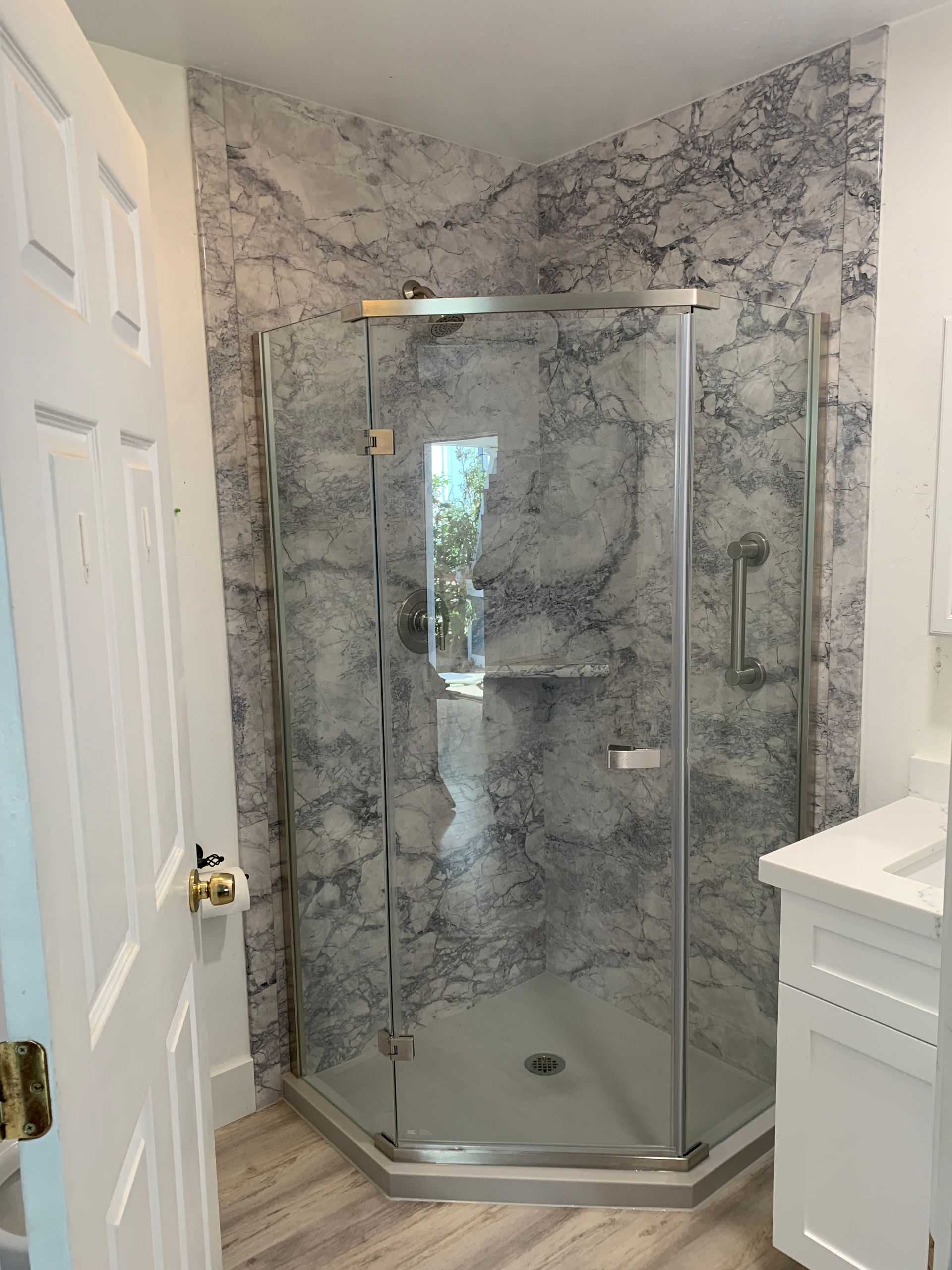 A bathroom with a walk in shower and a sink.