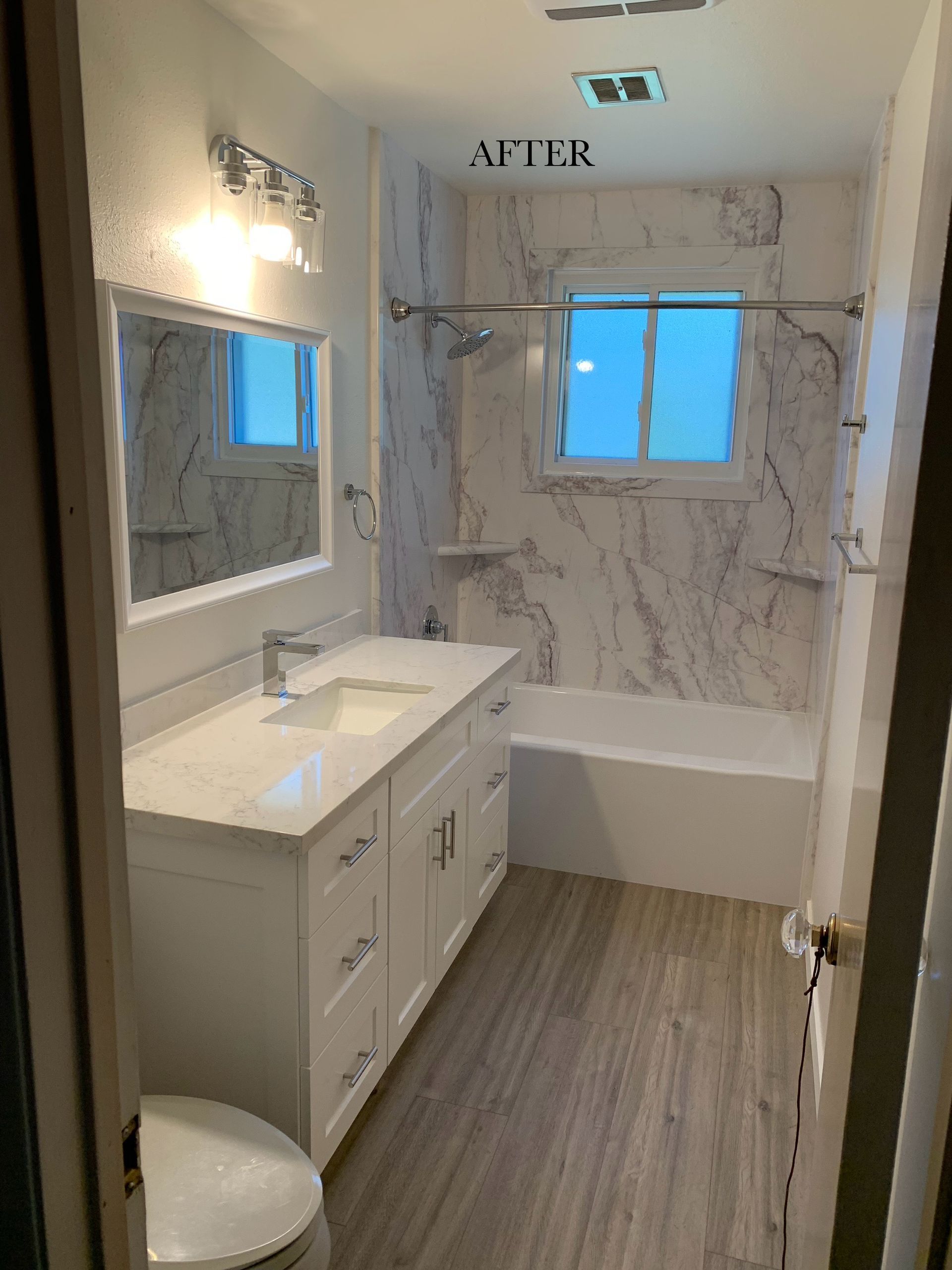 A bathroom with a sink , toilet , tub and mirror.