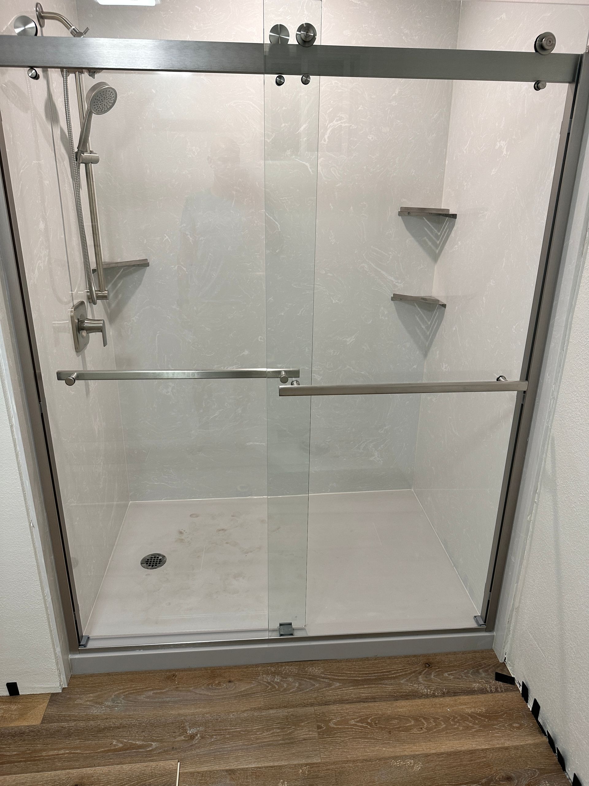 A bathroom with a sliding glass shower door and a shower head.