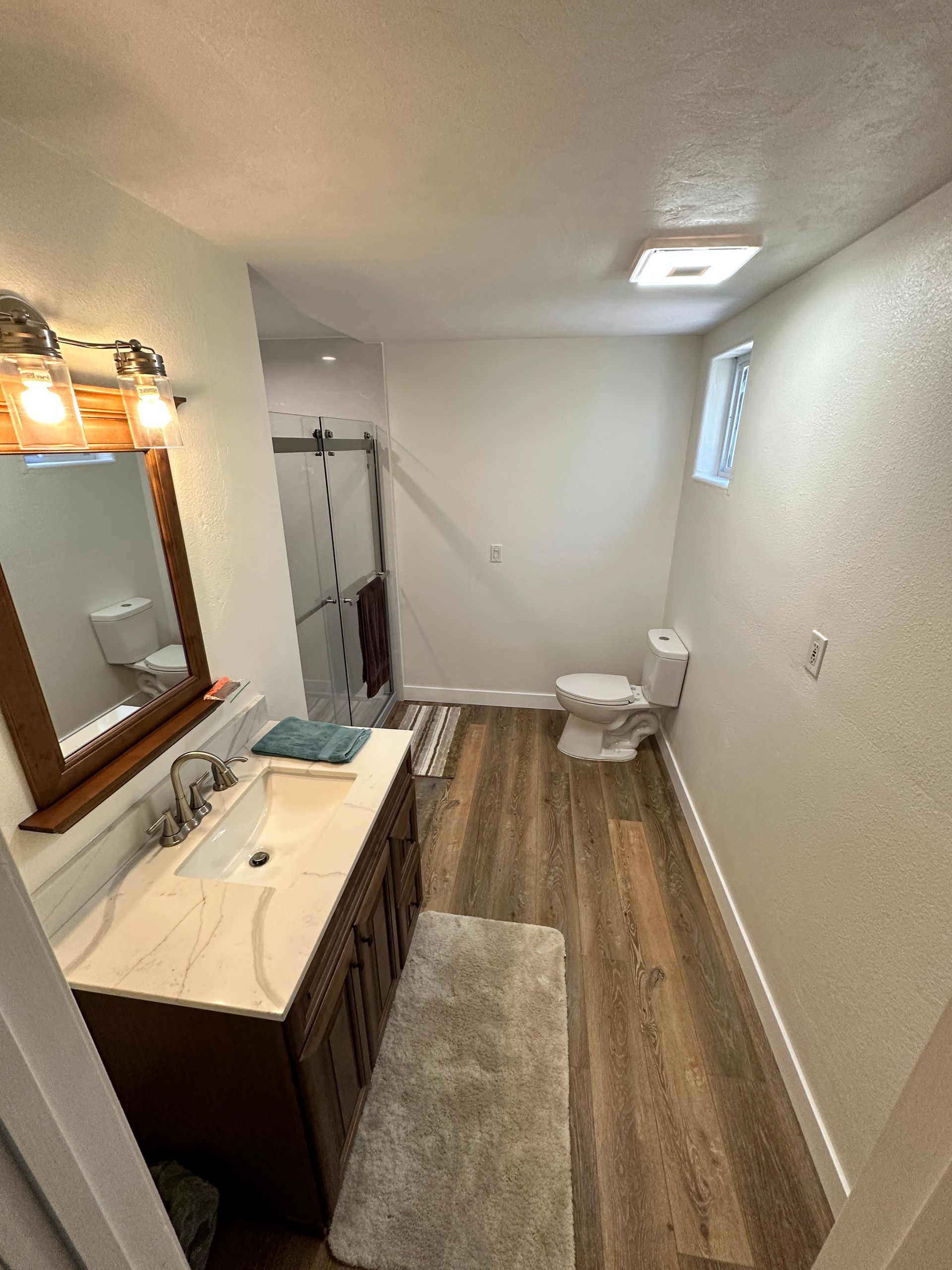 A bathroom with a sink , toilet and mirror.