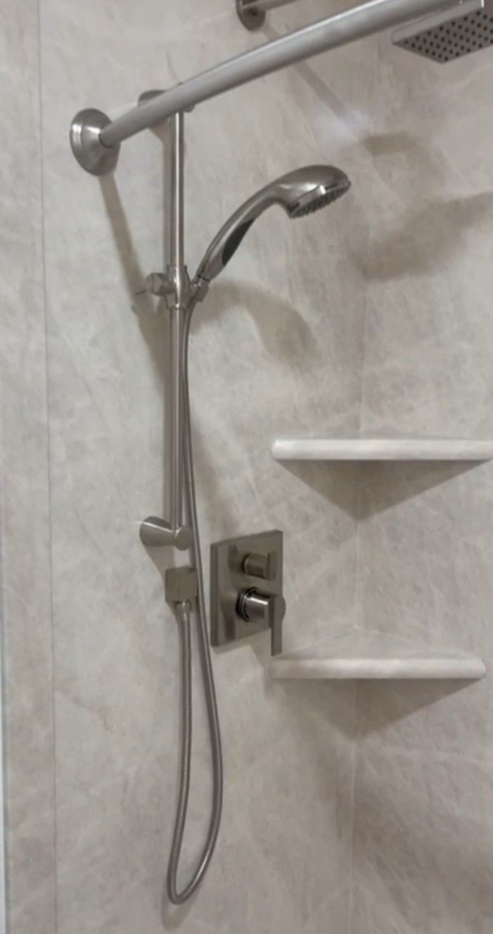 A close up of a shower head in a bathroom.