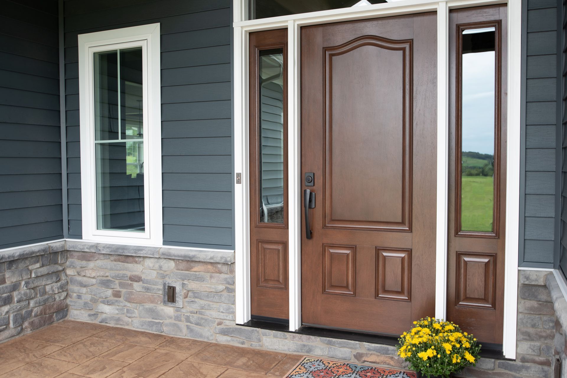 The front door of a house with a wooden door and two windows