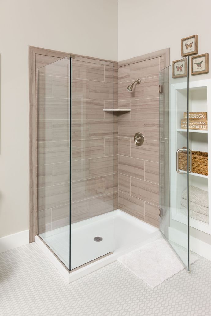 A bathroom with a walk in shower with a glass door.