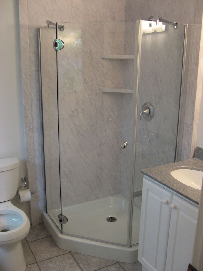 A bathroom with a toilet a sink and a shower stall