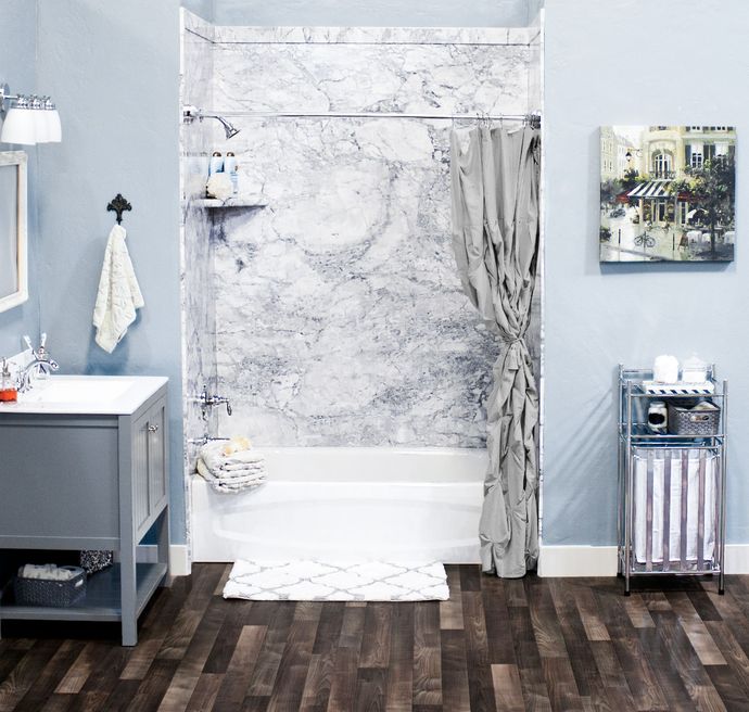 A bathroom with a bathtub a sink and a picture on the wall