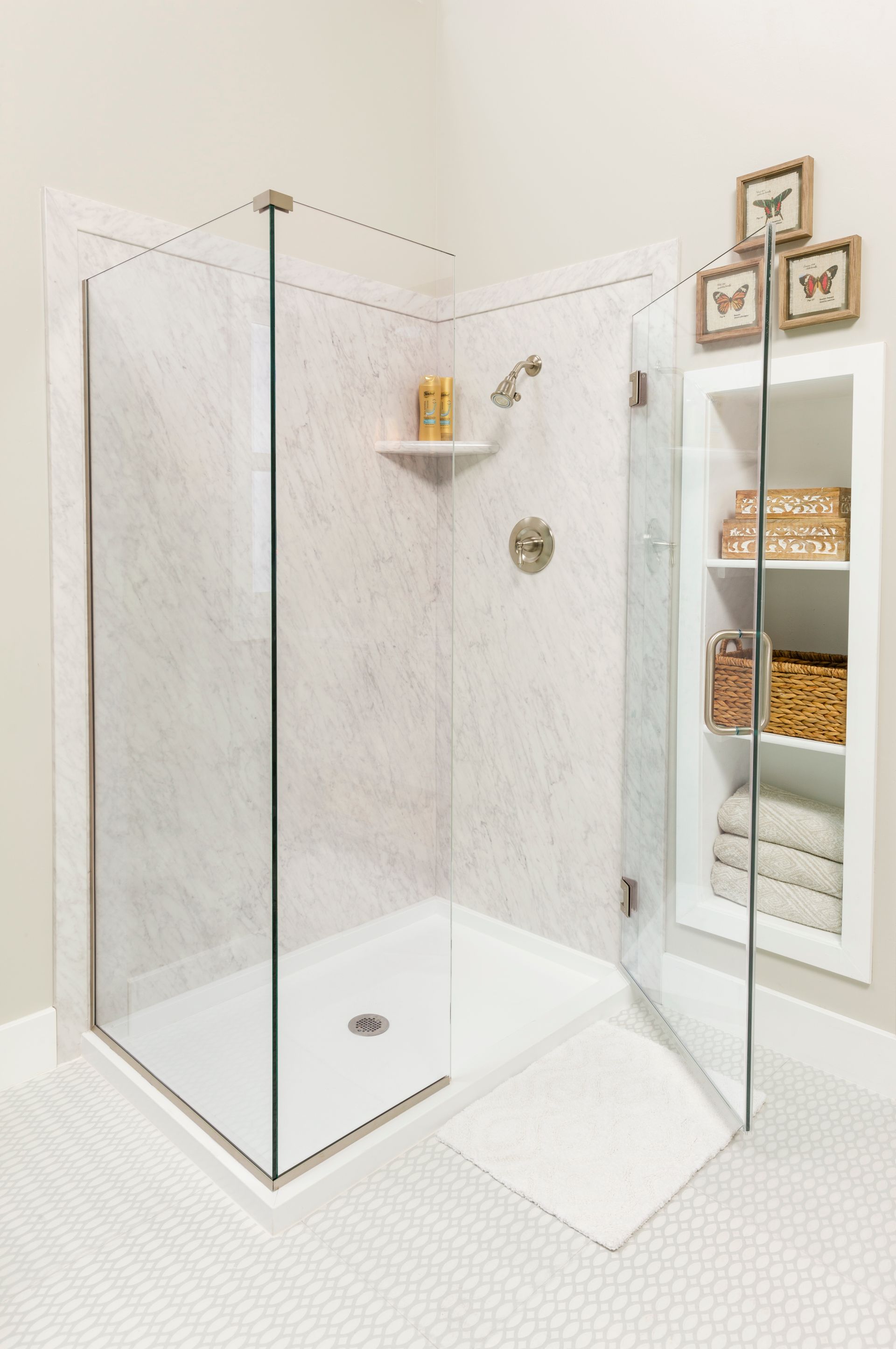 A bathroom with a walk in shower with a glass door.