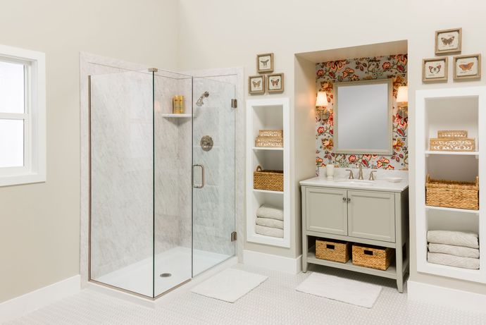 A bathroom with a walk in shower , sink and mirror.