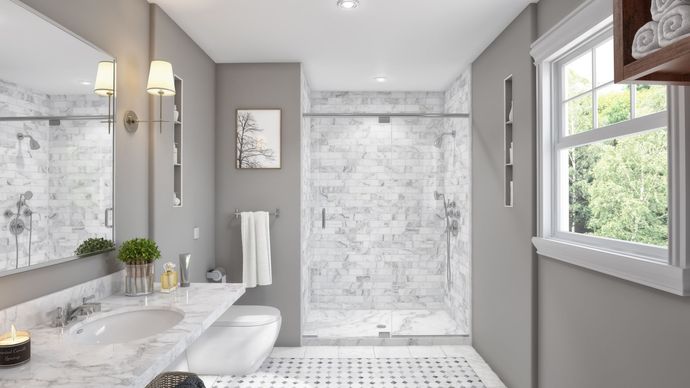 A bathroom with a walk in shower , sink , mirror and window.