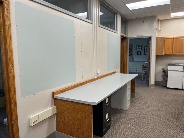 A room with a desk and cabinets in it