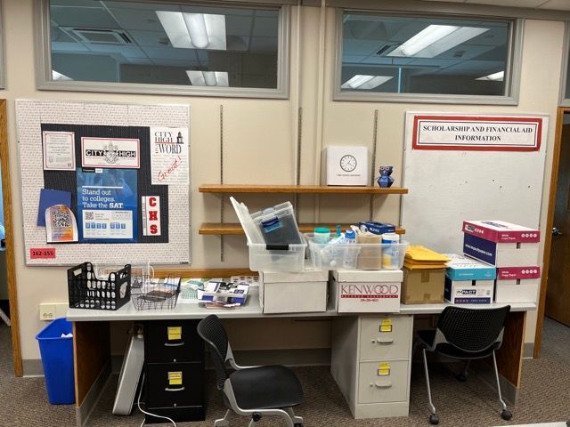 A room with a bulletin board and a desk with boxes on it