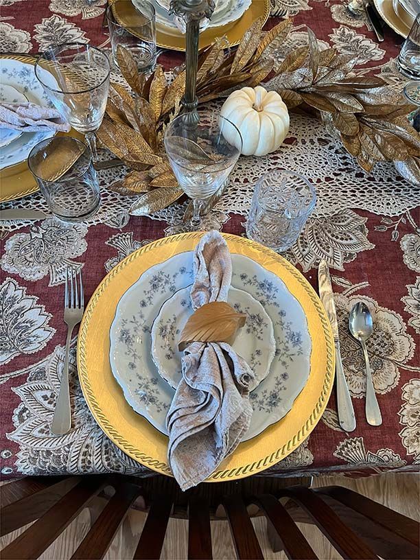 A table set for a thanksgiving dinner with plates , utensils , and a napkin.