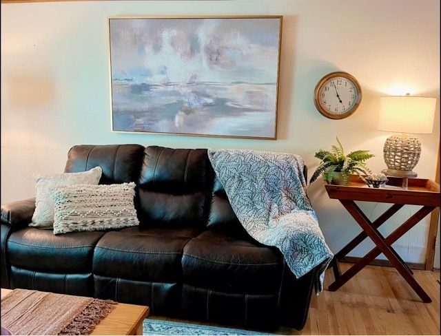 A living room with a couch and a clock on the wall
